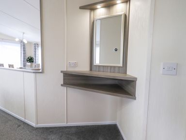 A hallway with a mirror and shelf at Lily's Lodge in Morecambe
