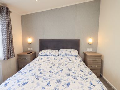 A bedroom with a bed and bedside tables at Lily's Lodge in Morecambe