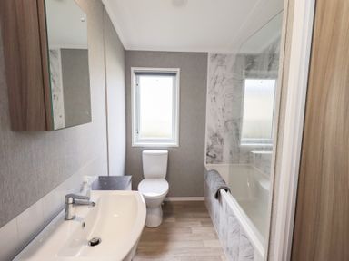 A bathroom with a sink, toilet, and bathtub at Lily's Lodge in Morecambe