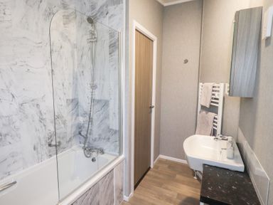 A bathroom with shower and bathtub at Lily's Lodge in Morecambe
