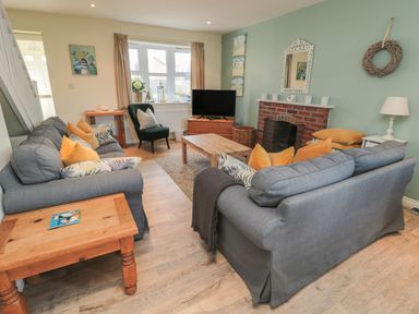 A living room with a television and seating area at Sandy Cove in Chathill