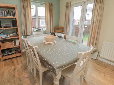 A dining room with a table and chairs at Sandy Cove in Chathill