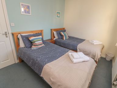A bedroom with two single beds at Sandy Cove in Chathill