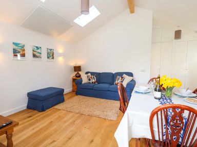 A living room with a sofa and dining table at The Pebble in Dorchester