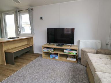 A living room with a television and games at Valley 36 in Kingsbridge