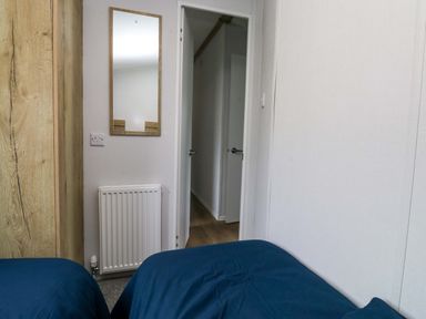 A bedroom with a mirror and radiator at Valley 36 in Kingsbridge