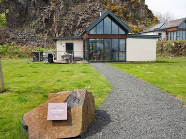 An exterior view of Summerset Lodge with a pathway and seating area