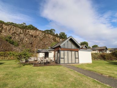 A house with a patio and pathway at Summerset Lodge in Bamburgh