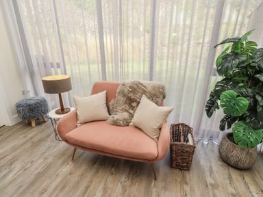 A living room with a sofa and plants at Summerset Lodge in Bamburgh