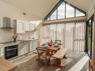 A kitchen with table and chairs at Summerset Lodge Bamburgh