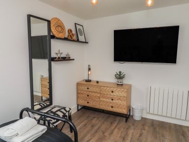 A bedroom with a mirror and television at Summerset Lodge in Bamburgh