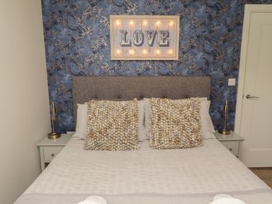 A bedroom with a bed and bedside tables at Summerset Lodge in Bamburgh