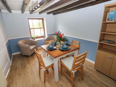 A dining room with a table set for four at Beacon House in Marloes near Little Haven