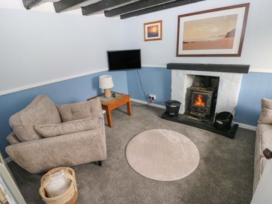 A living room with a fireplace and seating area at Beacon House Marloes near Little Haven