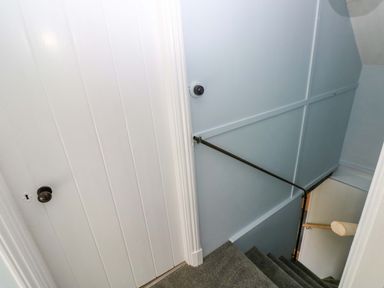 A staircase with a handrail and door at Beacon House Marloes near Little Haven