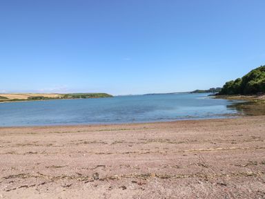 A beach with water and vegetation at Beacon House Marloes near Little Haven