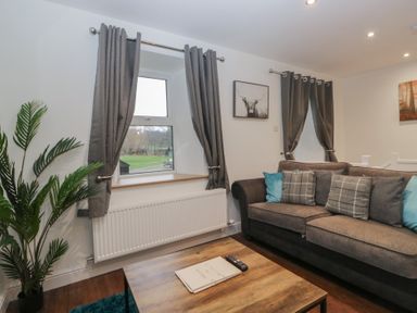 A living room with a sofa and window at 6 Hallin Fell in Penrith