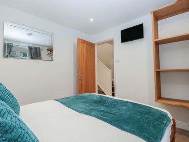 A bedroom with a bed and mirror at 6 Hallin Fell in Penrith