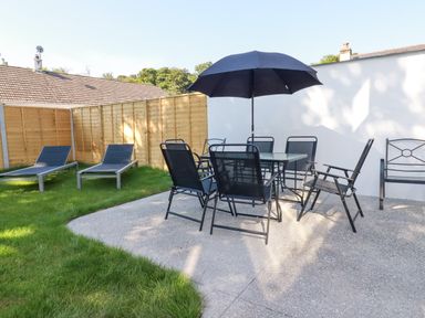 A garden with dining set and sun loungers at Creek Lodge in Chacewater