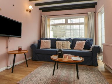 A living room with a sofa and coffee table at 1 Alpha Cottages in Tenby