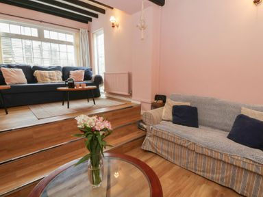 A living room with two sofas and a flower vase at 1 Alpha Cottages in Tenby