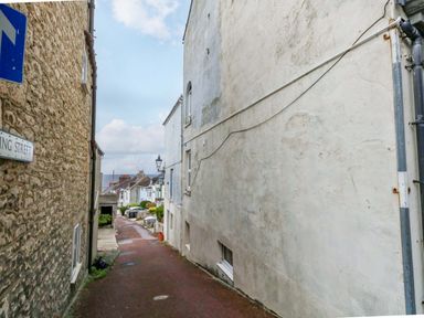 An alley with buildings on both sides and a street sign at Flat 3