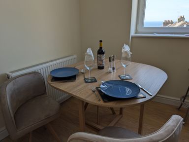 A dining table set with wine glasses and a bottle of wine at Flat 3 in Fortuneswell