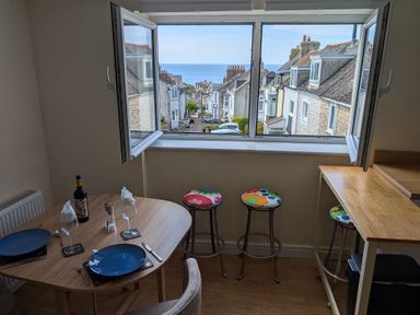 A dining room with a table and chairs overlooking a street at Flat 3 in Fortuneswell
