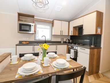A kitchen with table set for dining at Caravan in Great Yarmouth
