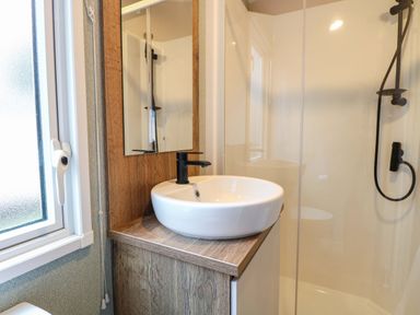 A bathroom with a sink and mirror at Caravan in Great Yarmouth