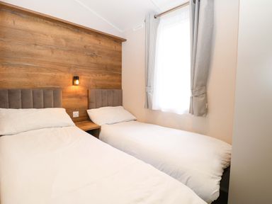 A bedroom with two beds and a window at Caravan in Great Yarmouth