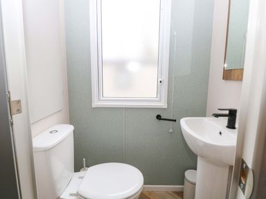 A bathroom with a toilet and sink at Caravan in Great Yarmouth