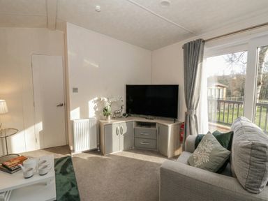 A living room with a television and sofa at The Ridgeway in New Quay