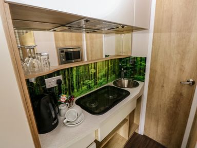 A kitchen with a cooking hob, sink, and appliances at The Pod in Ferryside