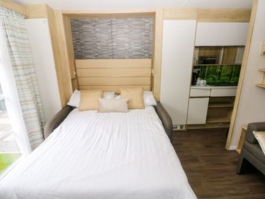 A bedroom with a bed and kitchenette at The Pod in Ferryside