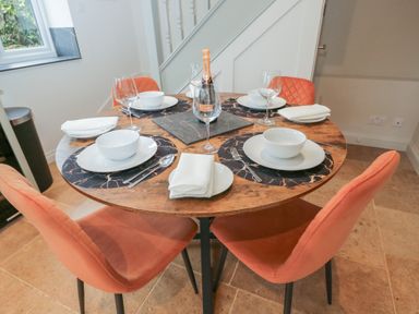 A dining table set with plates and wine glasses at Paddock View Stow-On-The-Wold