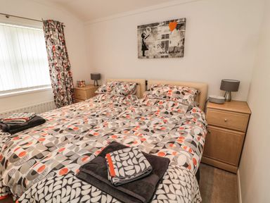 A bedroom with a double bed and bedside tables at Nevaeh Lodge Longframlington