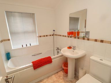 A bathroom with bathtub, sink, and toilet at Nevaeh Lodge Longframlington