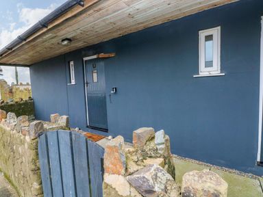 A front entrance with a door and stones at Red Kite Cottage Haverfordwest