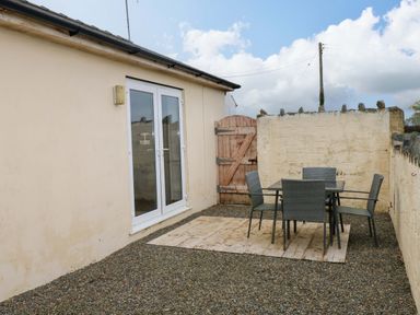 An outdoor area with a table and chairs at Red Kite Cottage in Haverfordwest