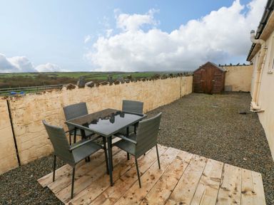 An outdoor area with a table and chairs at Red Kite Cottage in Haverfordwest