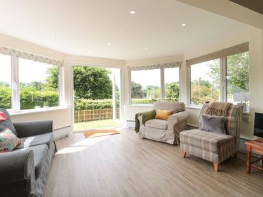 A snug with various seating and large windows at Ammerham Farm Cottage in Ammerham near Winsham