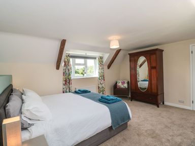 A bedroom with a bed and wardrobe at Ammerham Farm Cottage Ammerham near Winsham