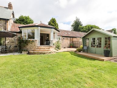A garden with a patio area and a shed at Ammerham Farm Cottage Ammerham near Winsham