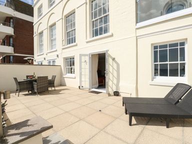 An outdoor area with a table and chairs at Ocean Wave in Greenhill