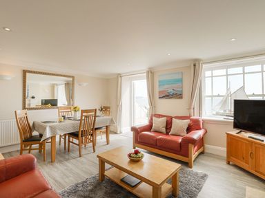 A living room with a dining area and sofa at Ocean Wave in Greenhill