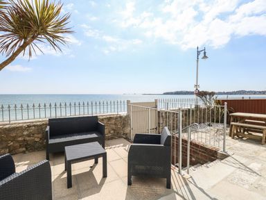 An outdoor seating area with sea view at Ocean Wave in Greenhill
