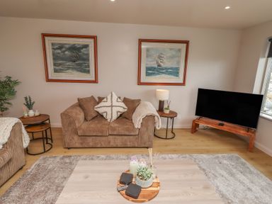 A living room with a sofa and TV at Tigh-Na-Mara Retreat