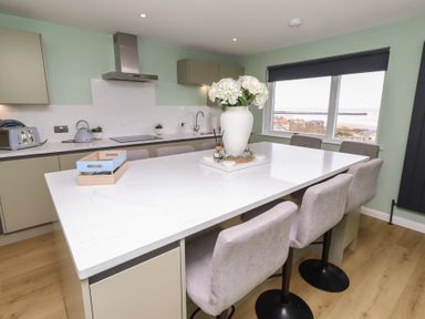 A kitchen featuring an island with bar stools at Tigh-Na-Mara Retreat
