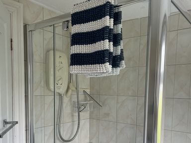 A shower with a towel hanging and a control panel at Chalet - Buckland 16, Bideford